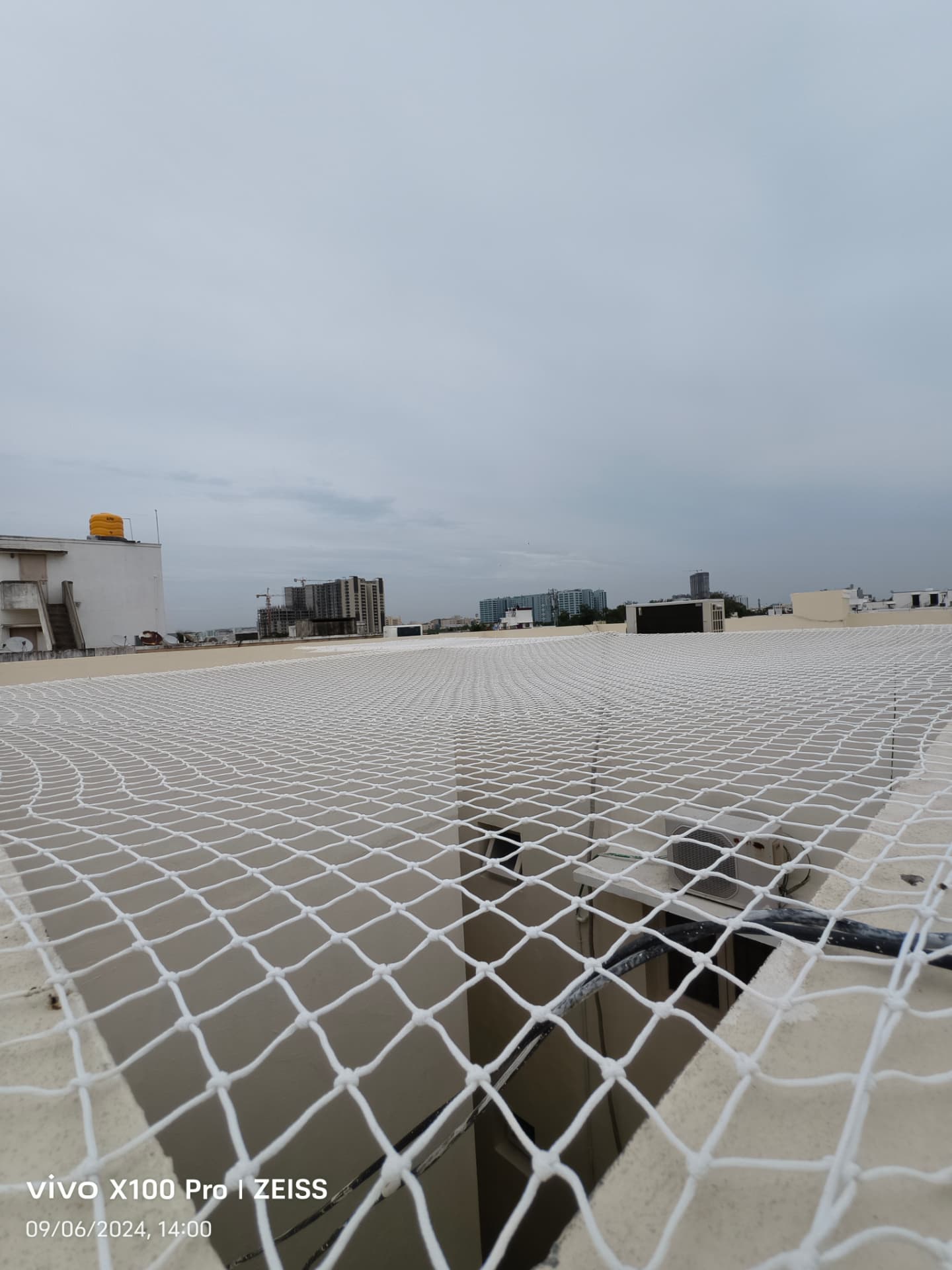 Pigeon net over an open rooftop shaft — general real YPL pigeon-net work in Chennai, property not identified