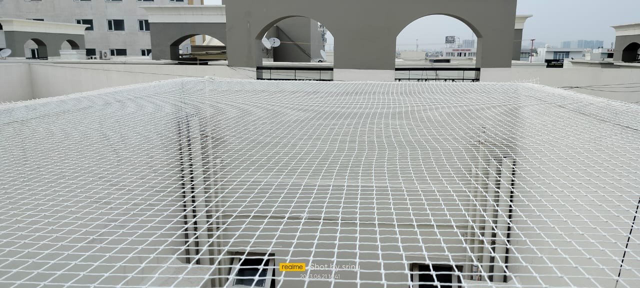 Pigeon net spanning an open building shaft — general real YPL pigeon-net work in Chennai, property not identified